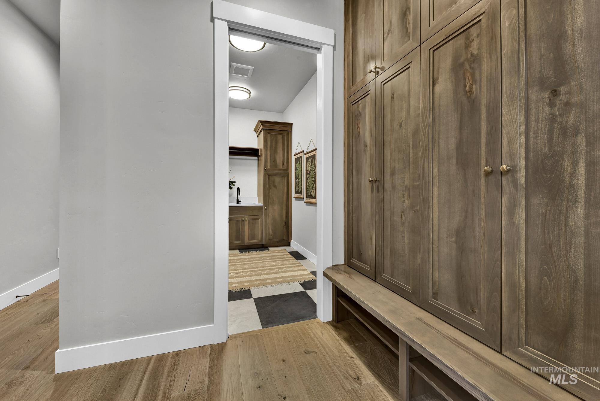 Mudroom featuring light wood-style floors and baseboards