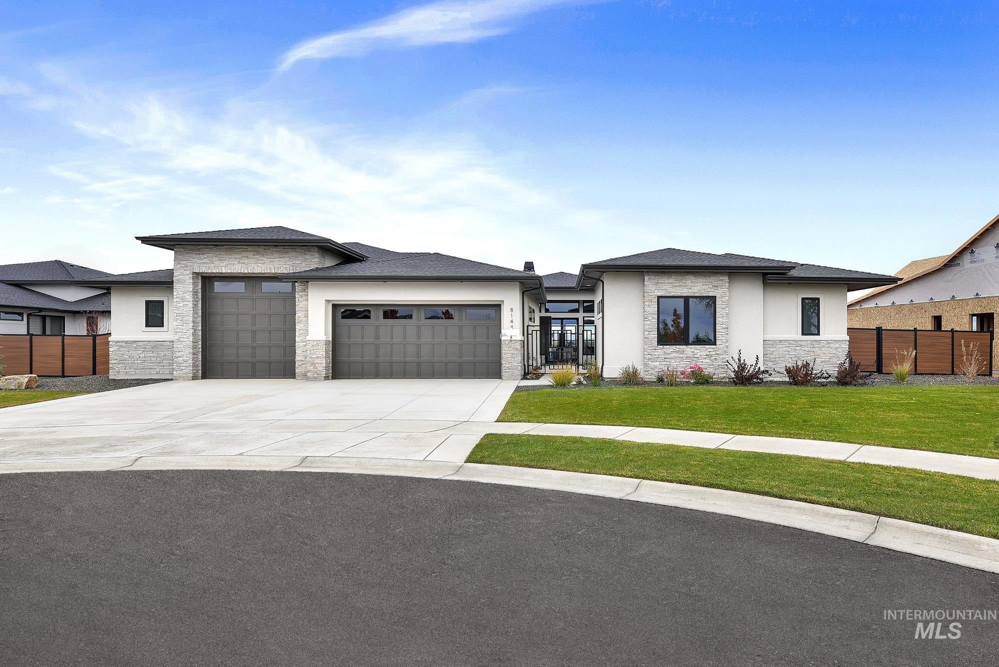 Prairie-style house featuring stone siding, an attached garage, concrete driveway, and stucco siding