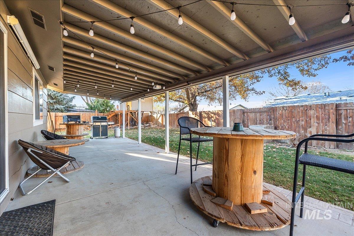 Fenced backyard with a patio area, a grill, and outdoor dining space