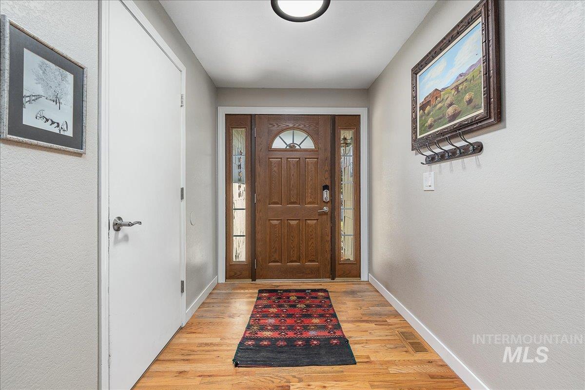 Foyer entrance featuring light wood-style floors and a textured wall