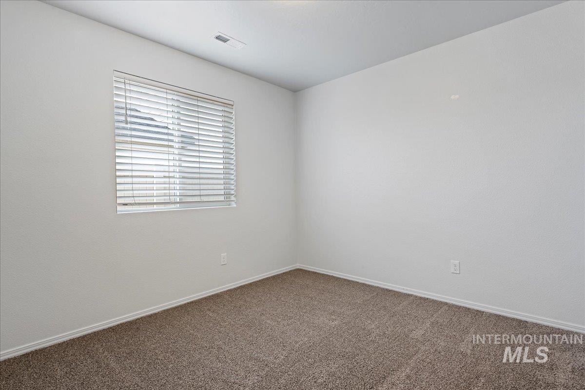 Carpeted empty room featuring baseboards