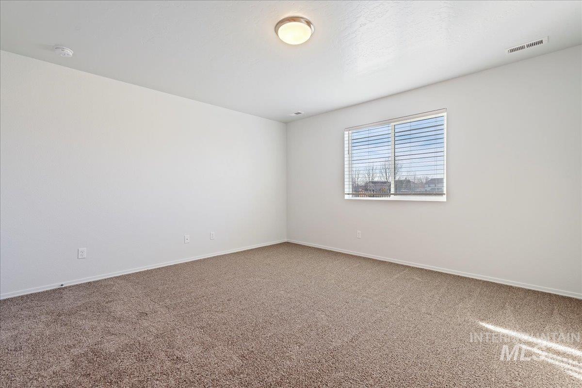 Carpeted empty room with baseboards