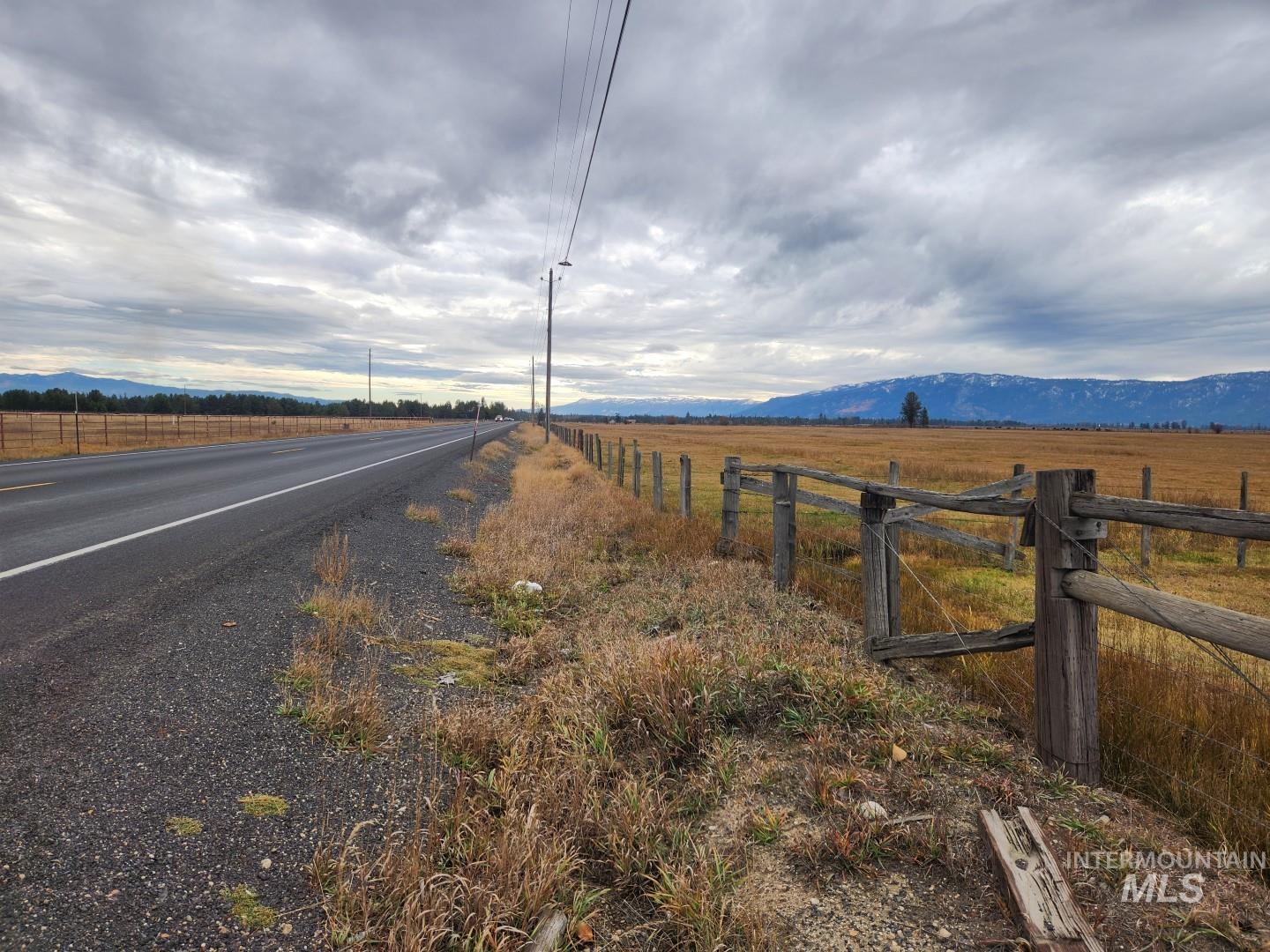 View of asphalt road with a view of rural / pastoral area and a mountain view