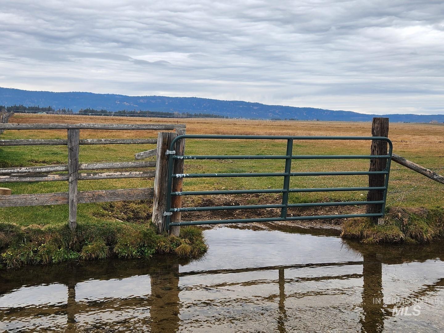 Gate with a water and mountain view and a rural view