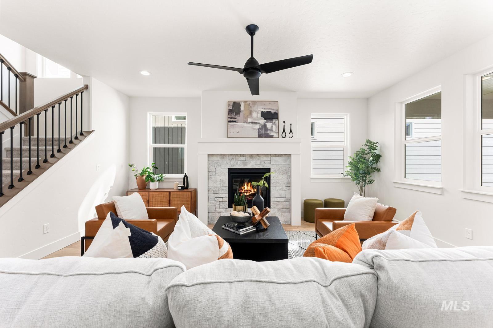 Living area with a fireplace, a ceiling fan, and recessed lighting