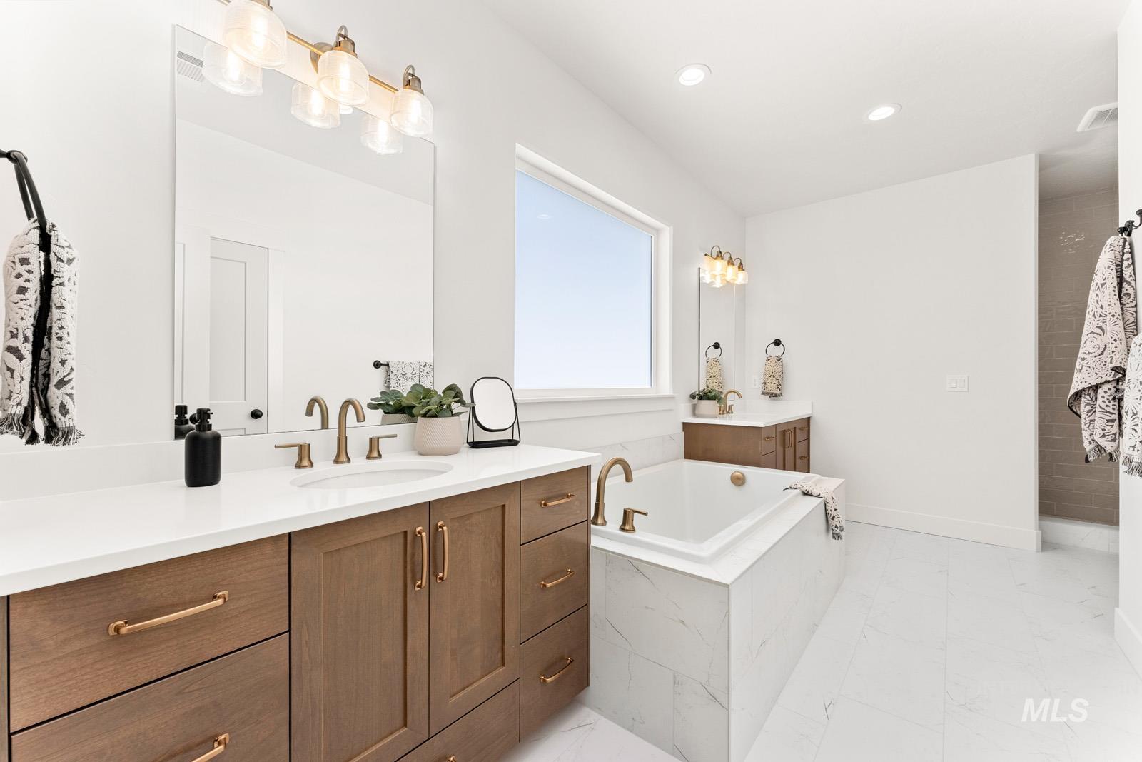 Bathroom featuring vanity, a bath, and recessed lighting