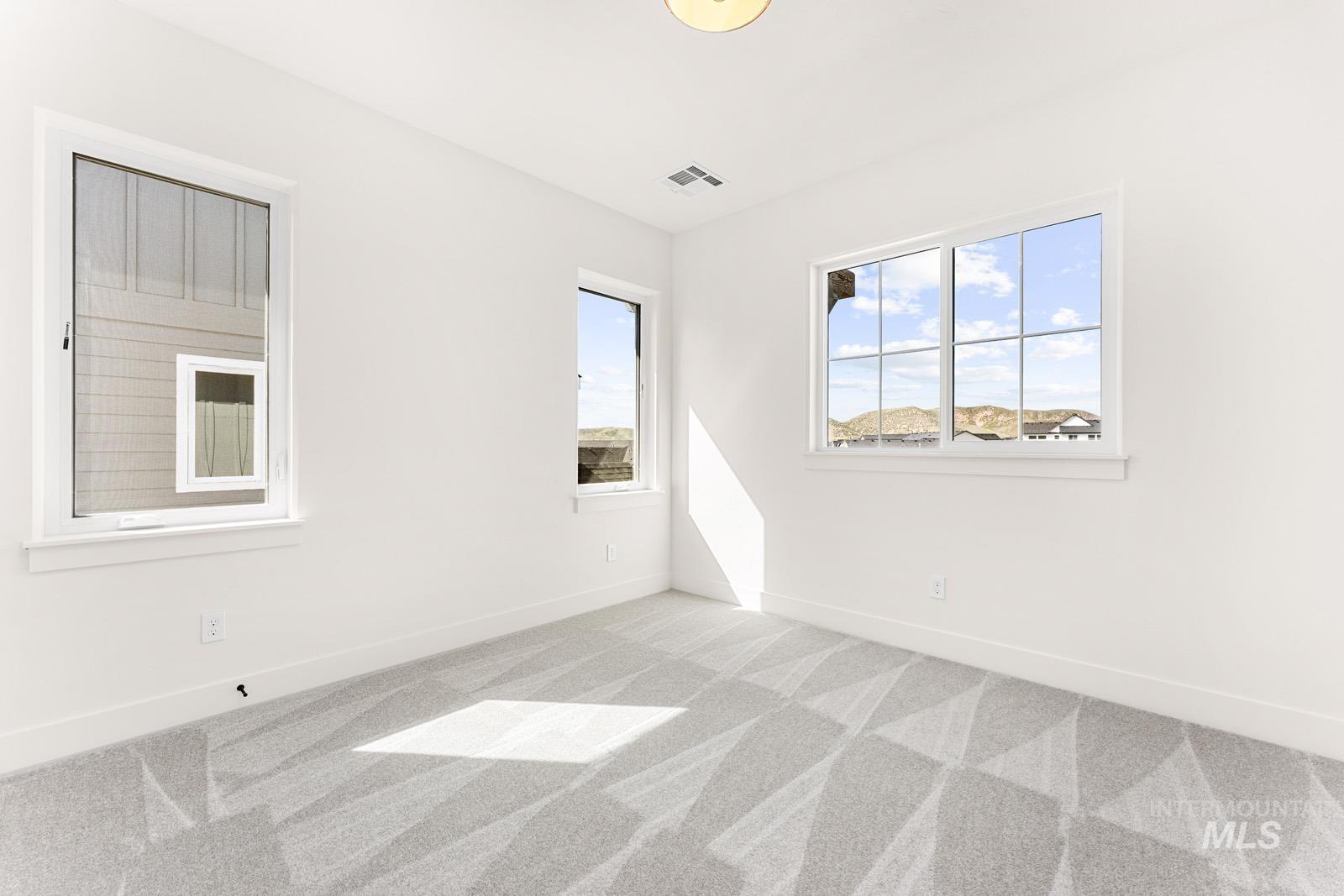 Spare room featuring light carpet and baseboards
