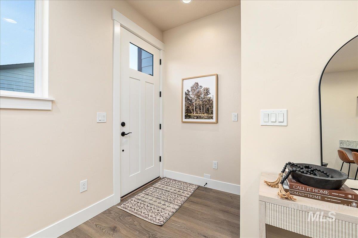 Entrance foyer with baseboards and wood finished floors