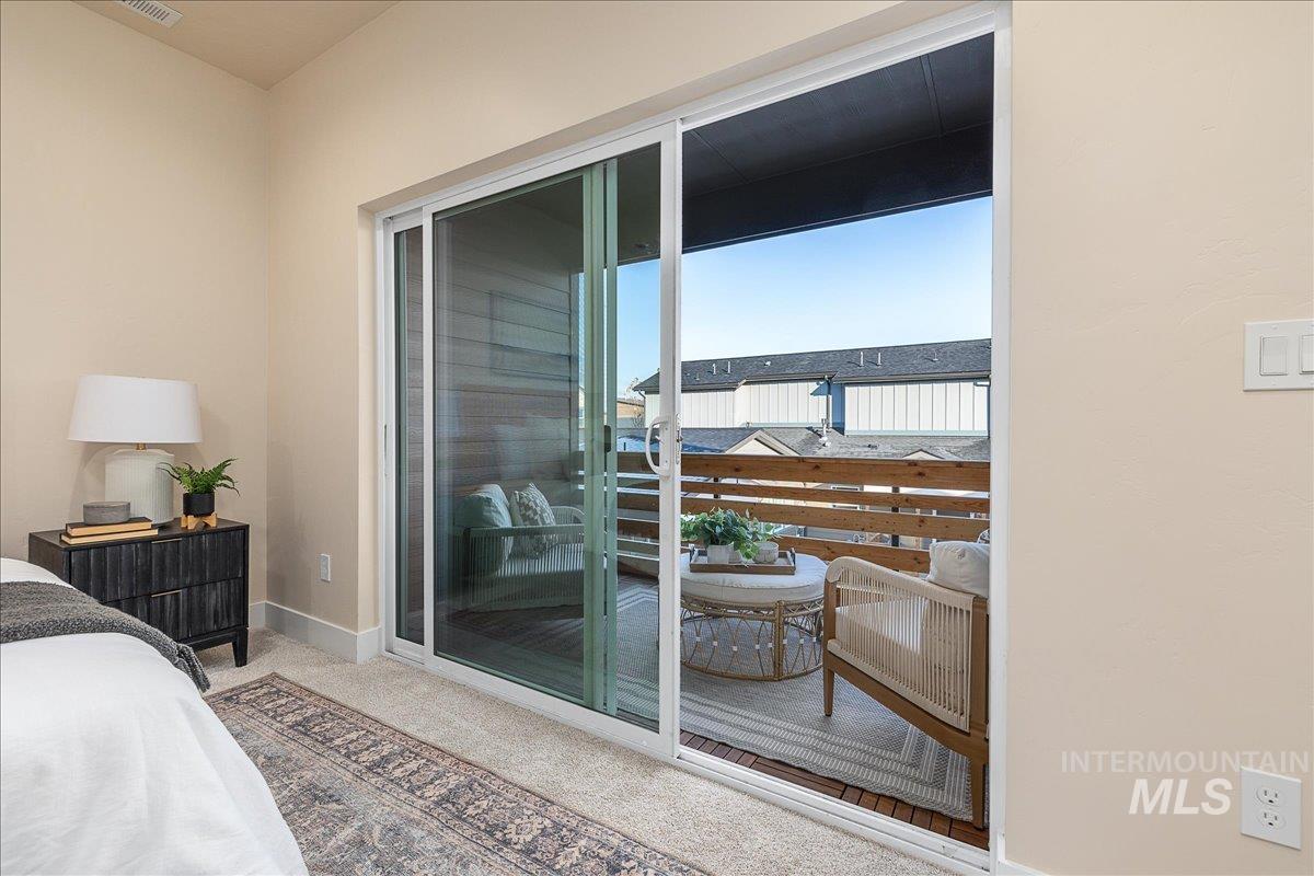 Bedroom featuring access to exterior and light carpet