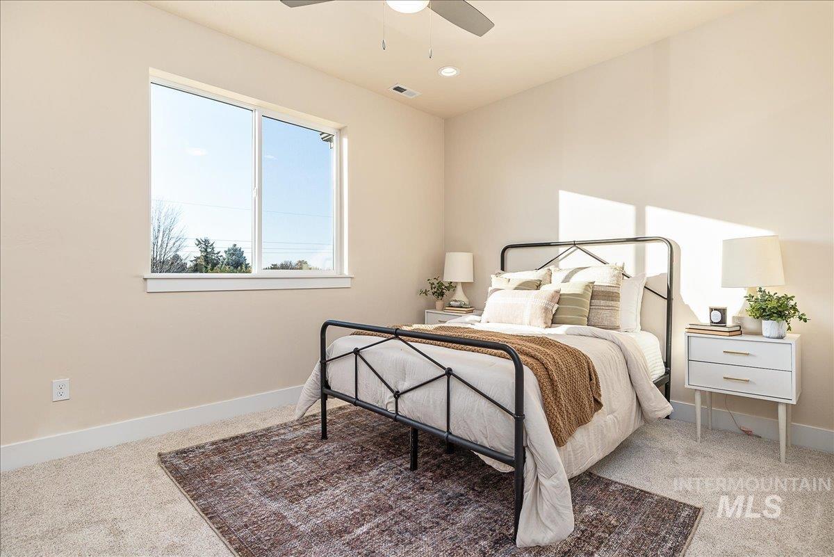 Bedroom featuring light colored carpet and ceiling fan