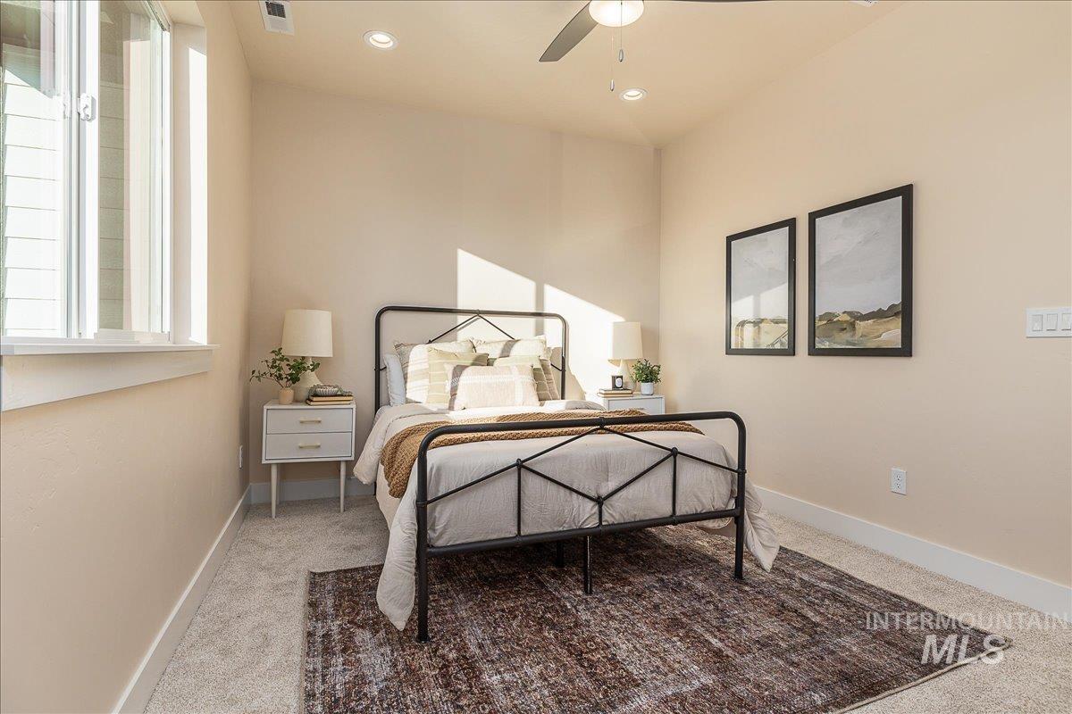 Bedroom with light colored carpet and ceiling fan