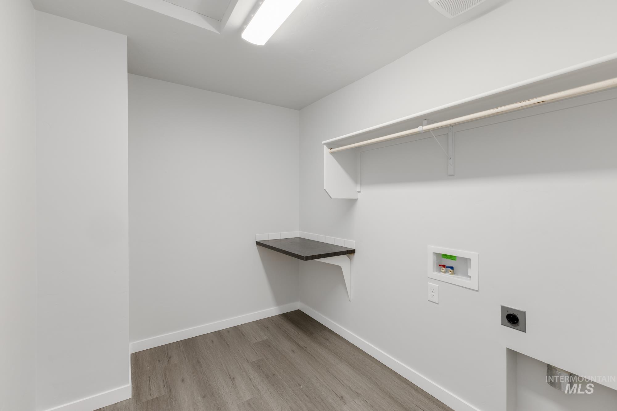 Laundry room with washer hookup, electric dryer hookup, and light wood-style floors