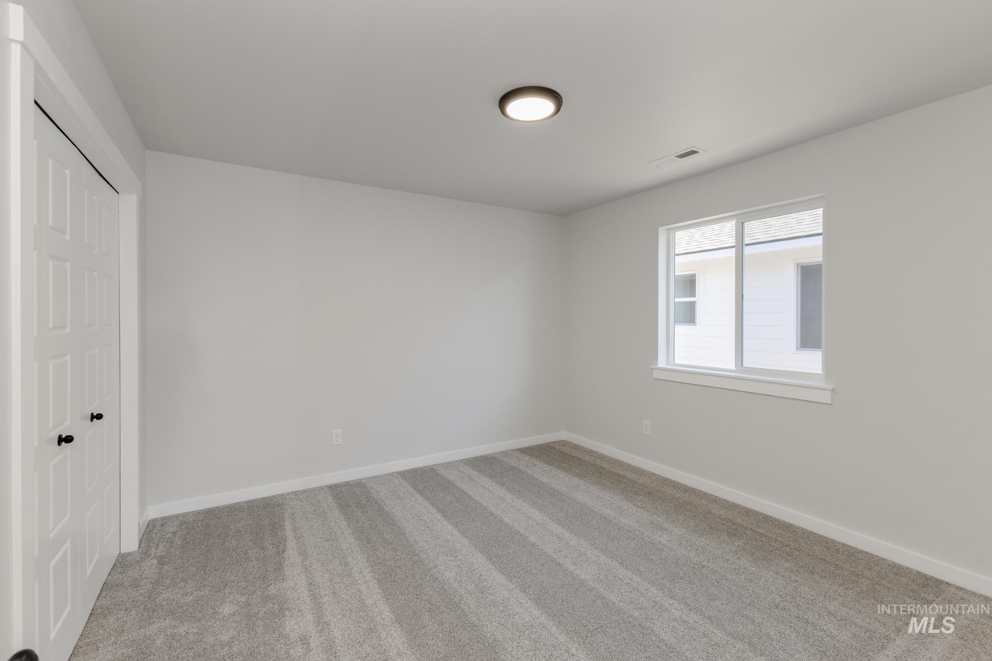 Unfurnished bedroom with a closet and light colored carpet