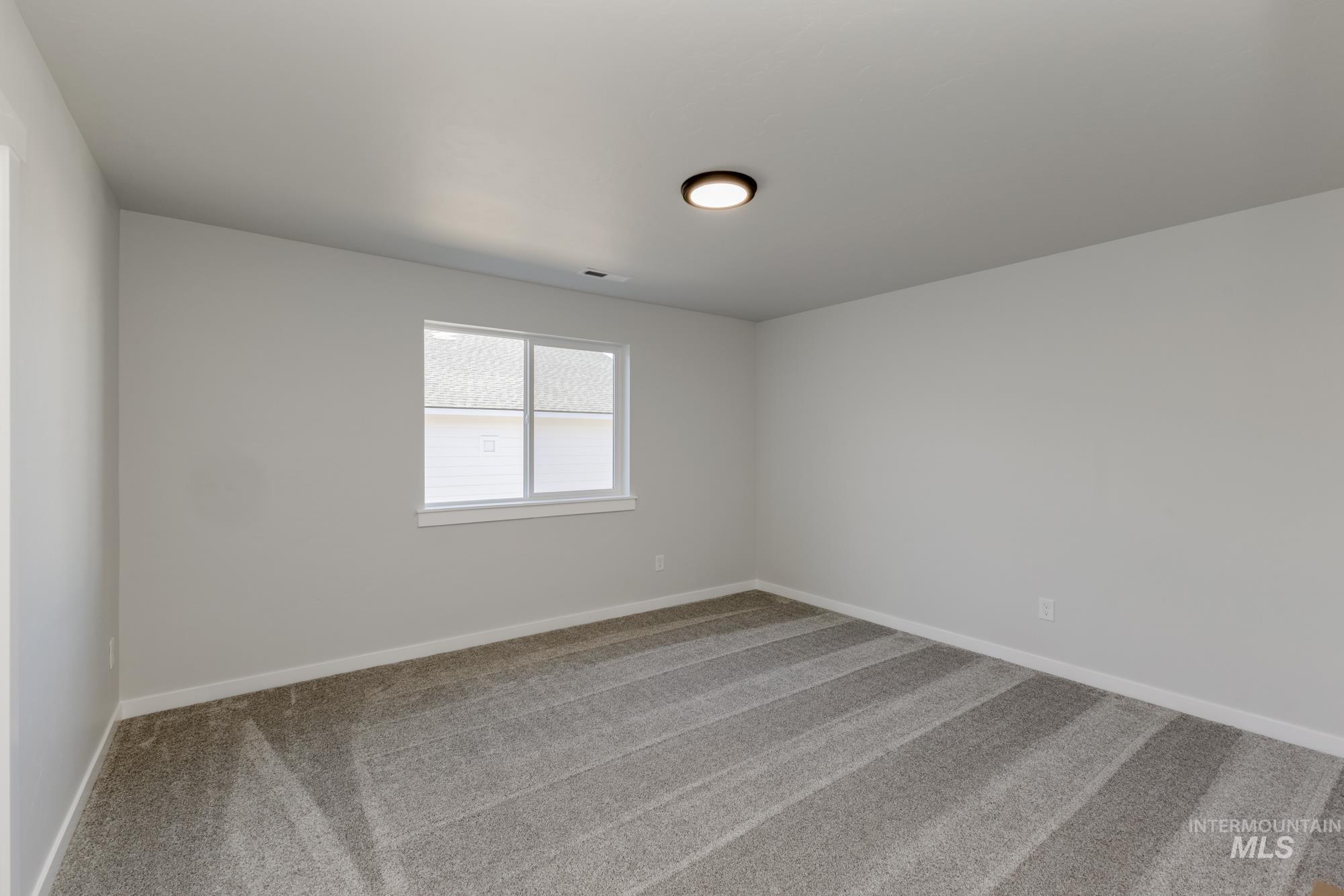 Carpeted spare room with baseboards