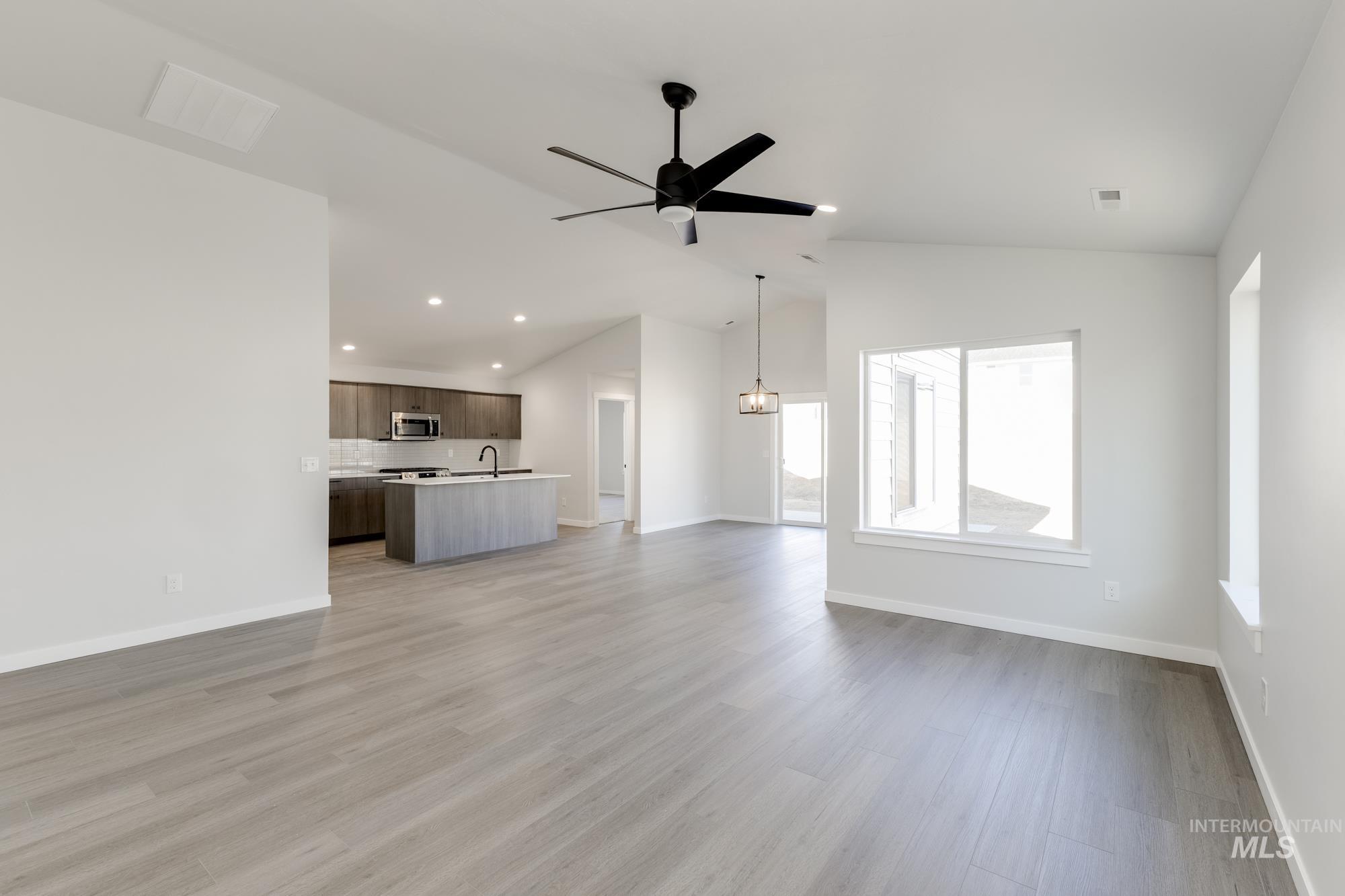 Unfurnished living room with vaulted ceiling, recessed lighting, light wood-type flooring, and ceiling fan