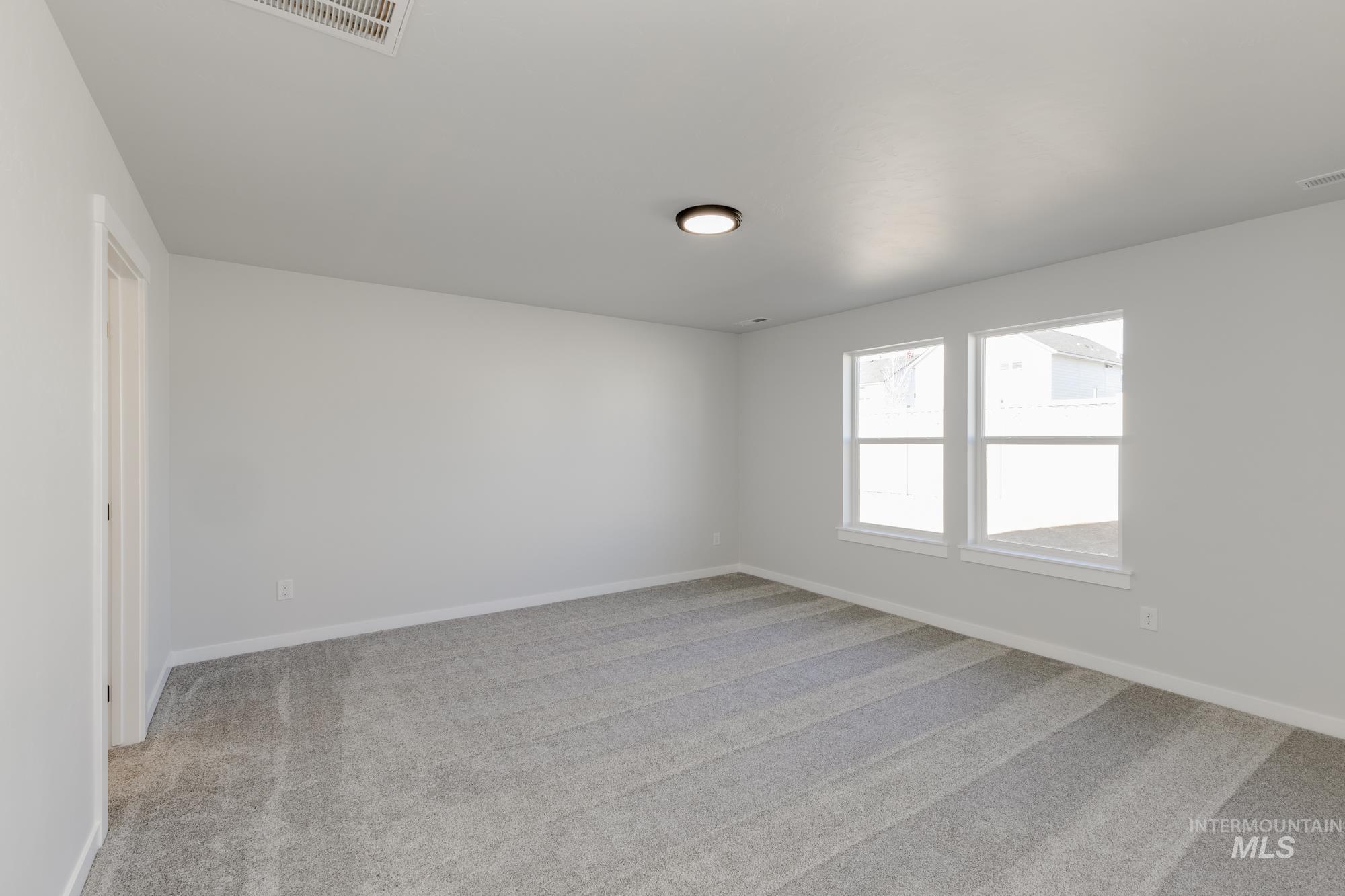 Spare room featuring light carpet and baseboards