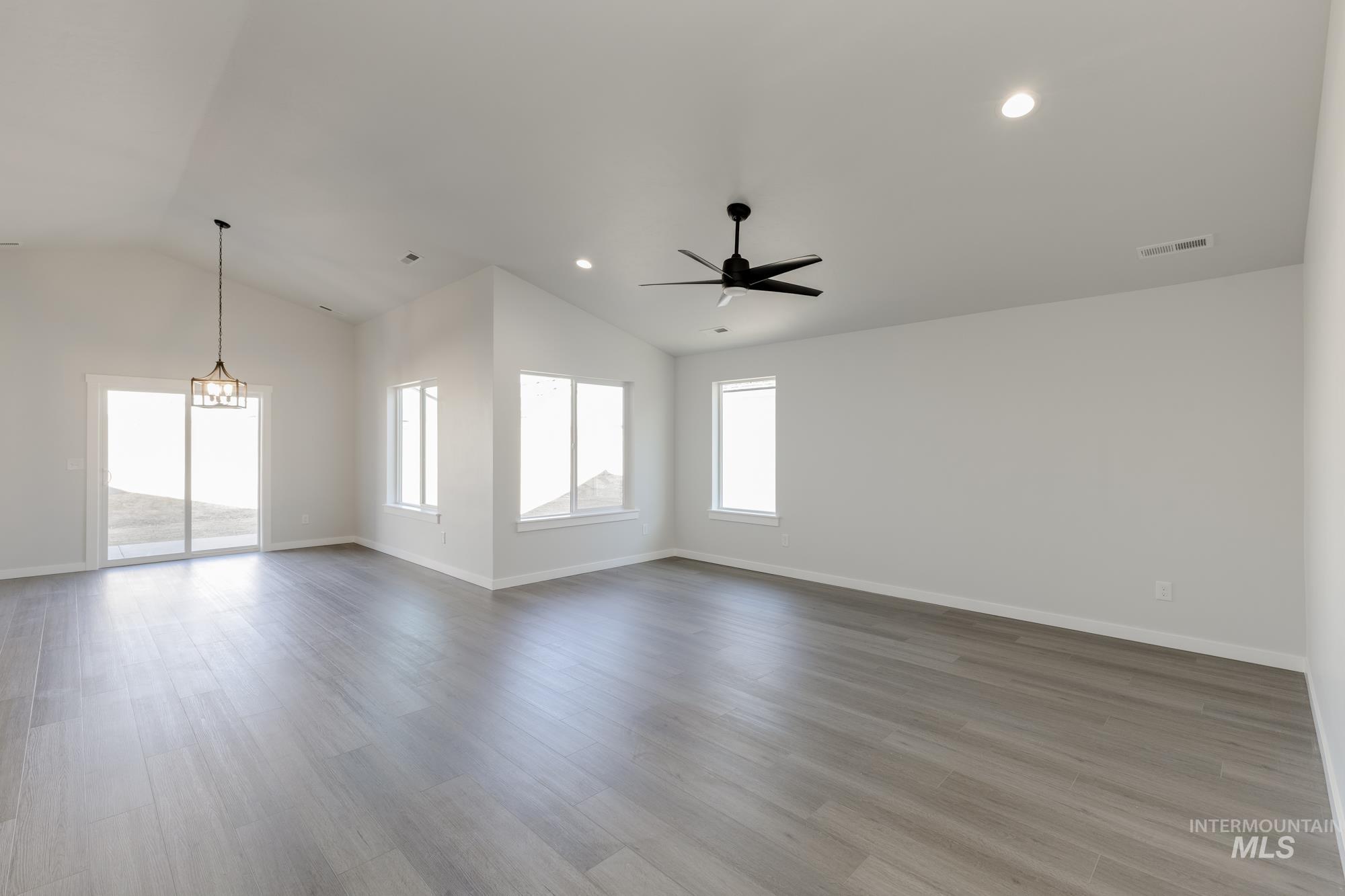 Empty room featuring lofted ceiling, light wood-type flooring, a ceiling fan, and recessed lighting
