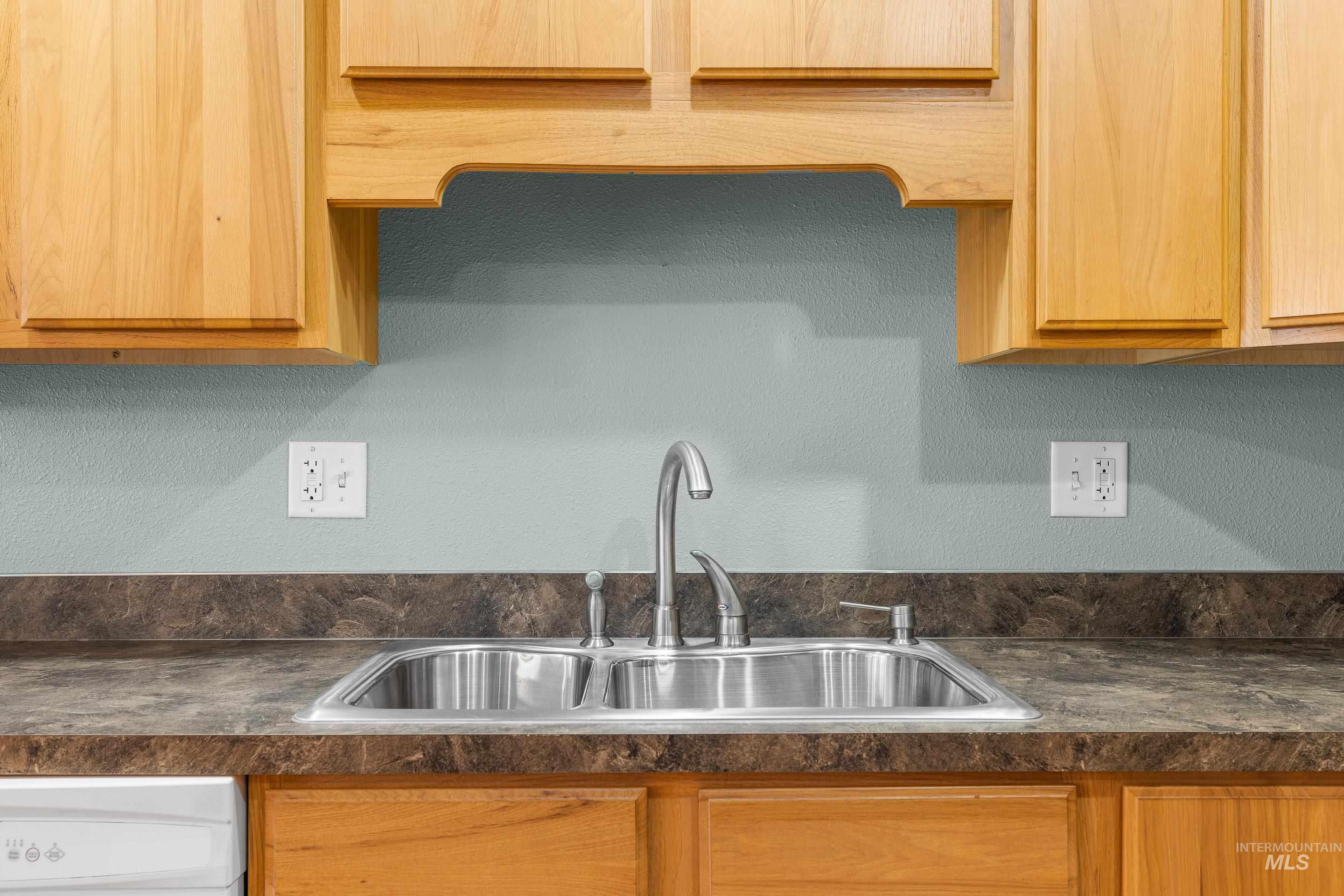 Kitchen with dark countertops and a textured wall