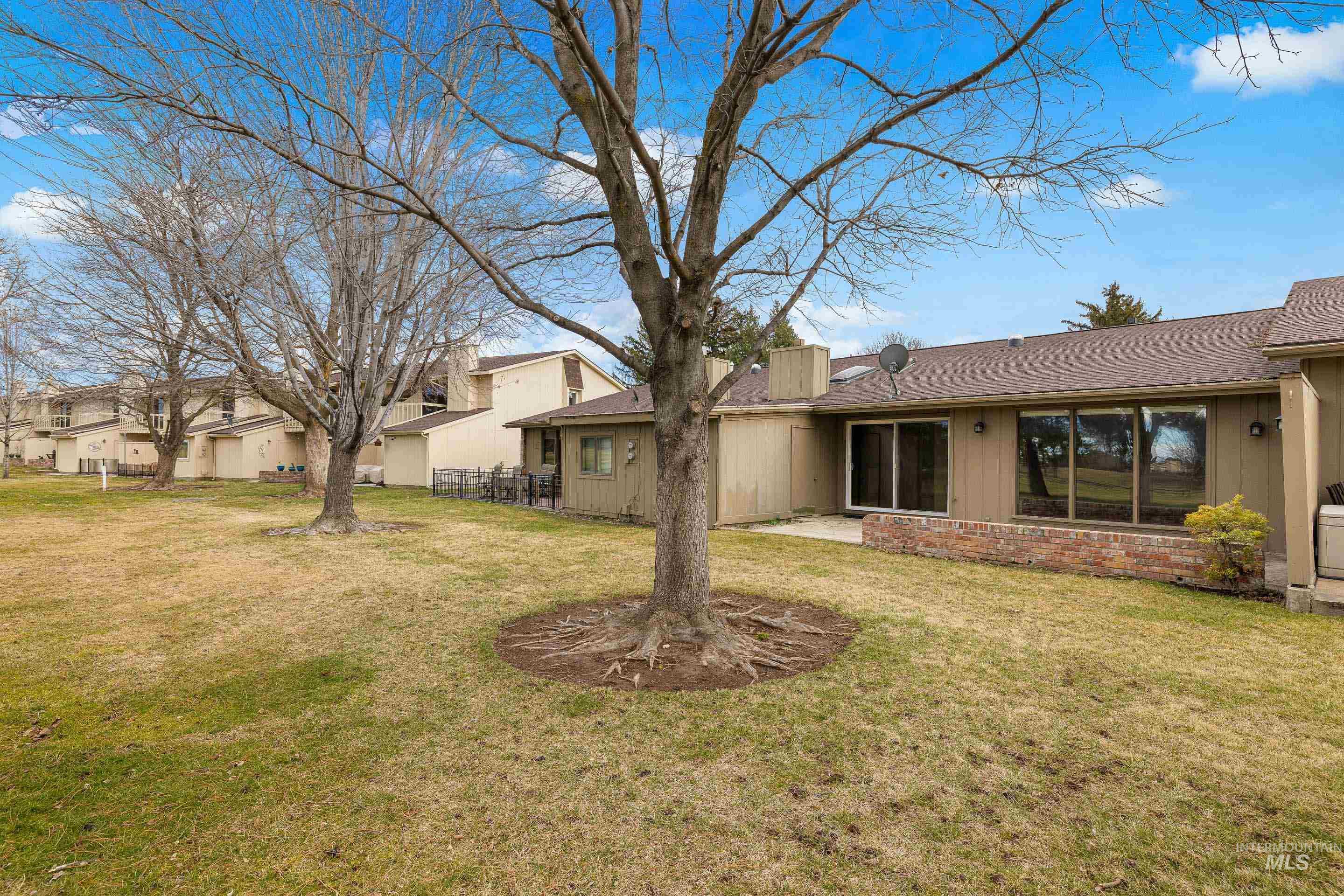 View of green lawn featuring a patio and a residential view