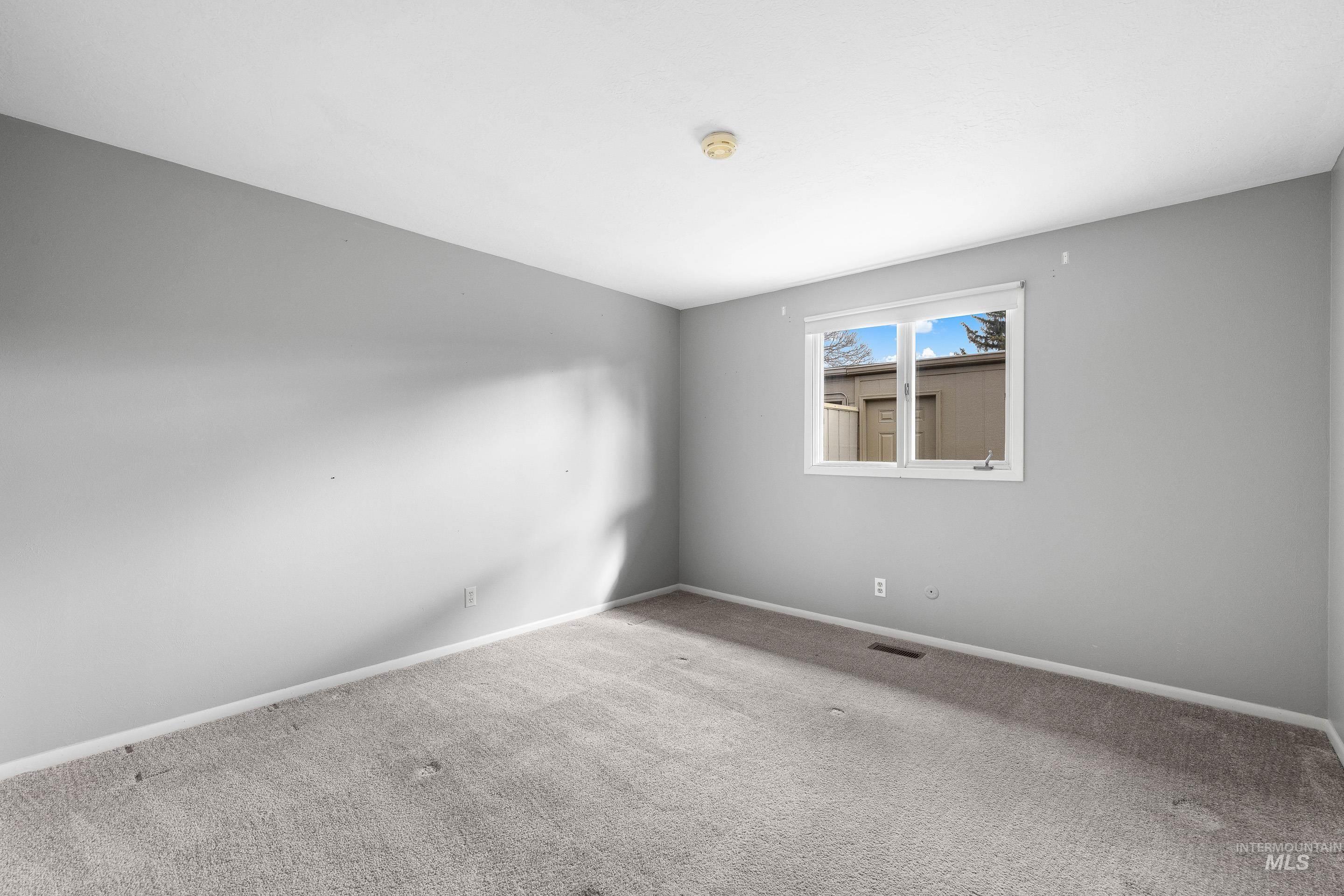 Spare room featuring baseboards and carpet floors