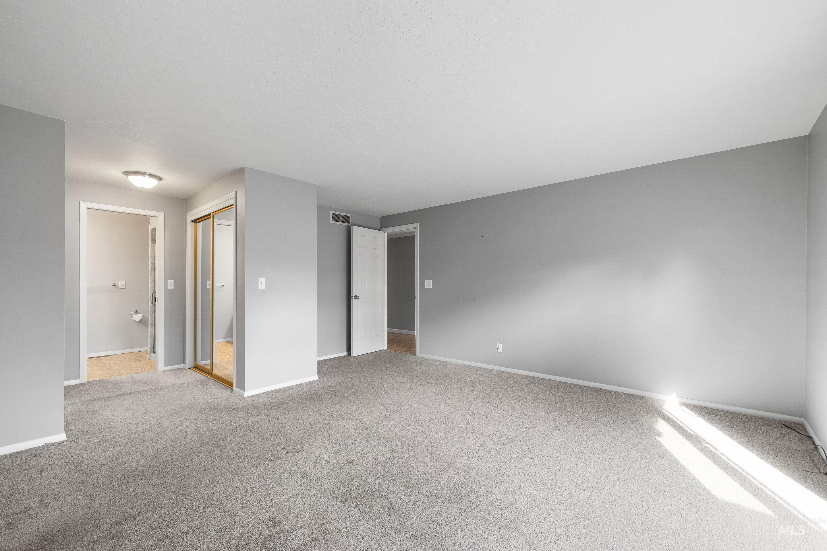 Empty room featuring light colored carpet