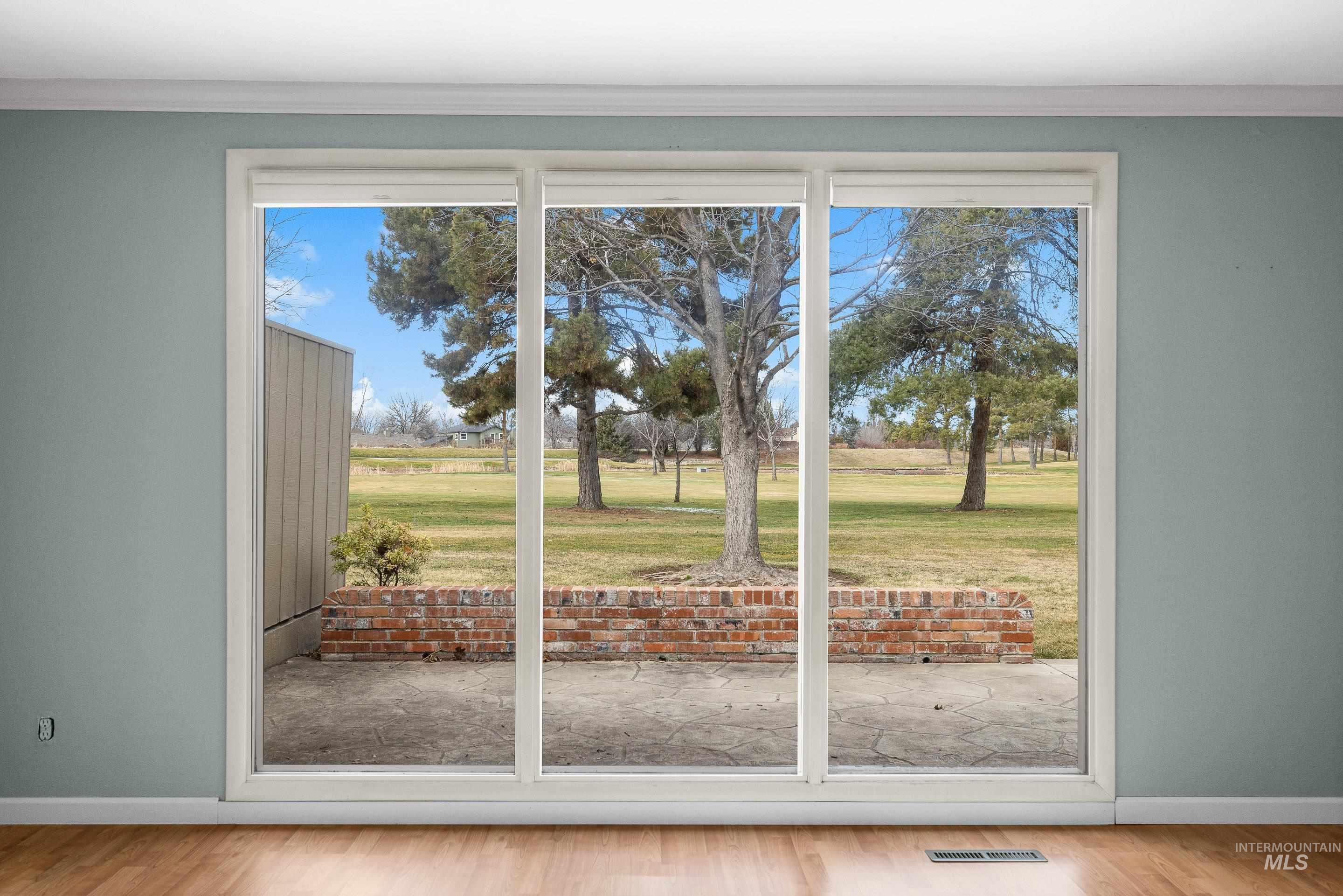 Entryway featuring wood finished floors, ornamental molding, and golf course view