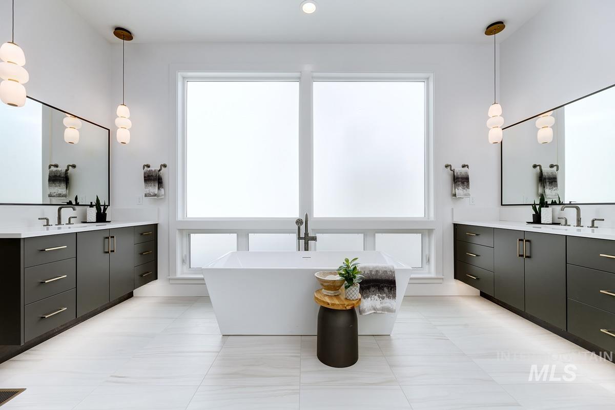 Full bath featuring two vanities and a freestanding tub