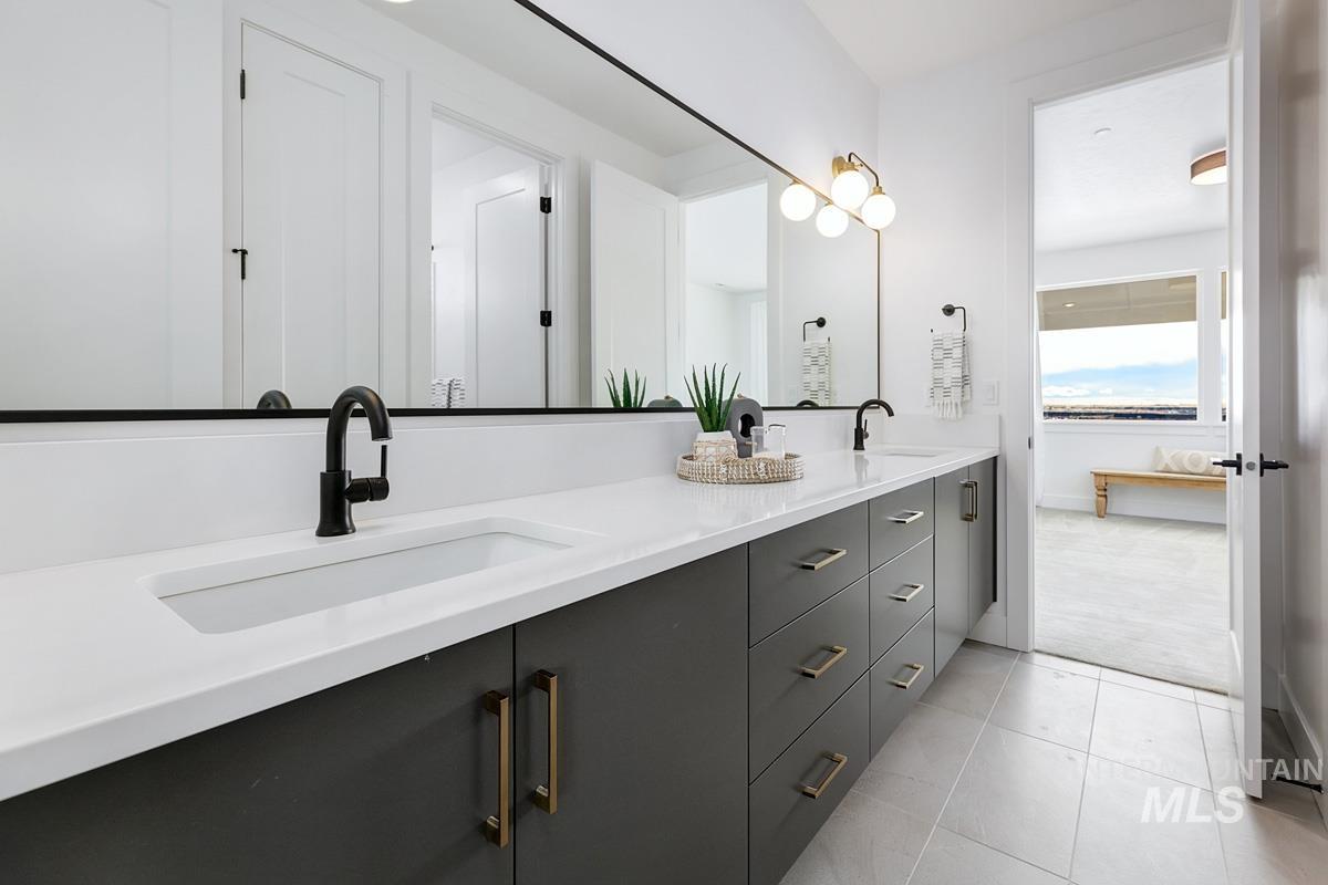 Bathroom with double vanity and light tile patterned floors