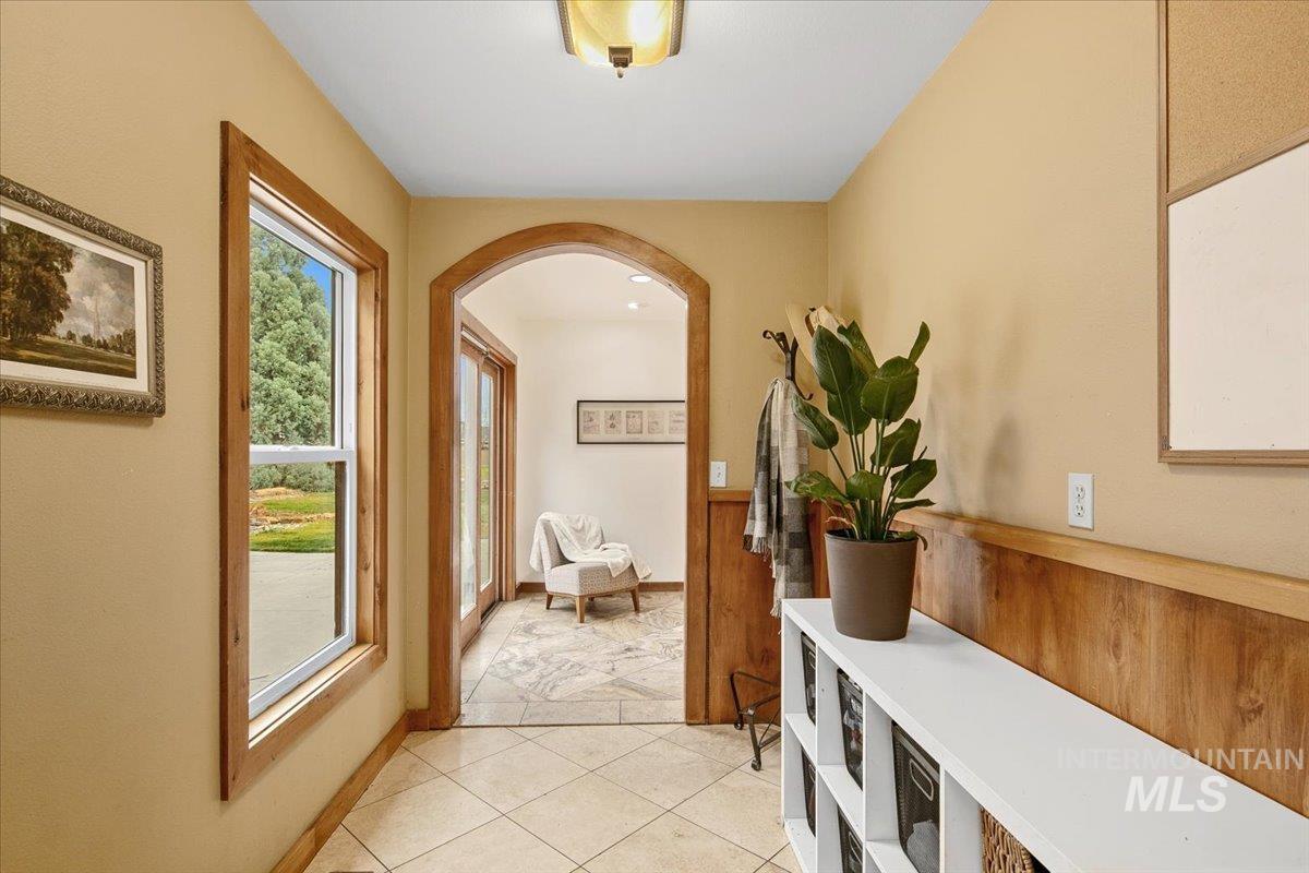 Entryway with tile patterned floors and arched walkways