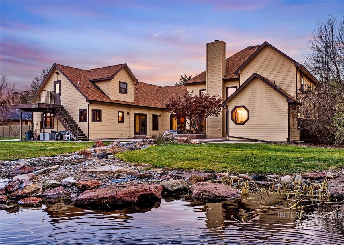Back of house featuring a lawn, a patio area, stairway, and a chimney