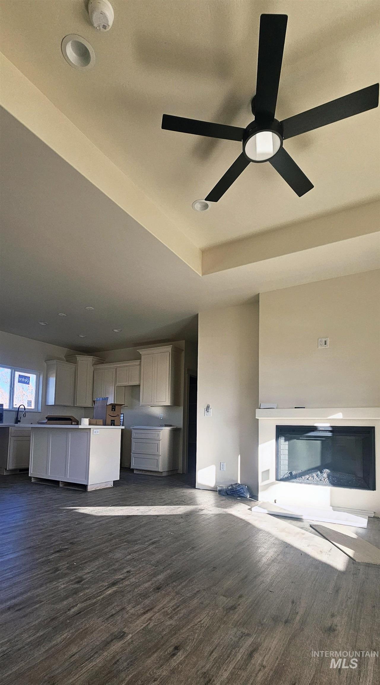 Unfurnished living room featuring dark wood finished floors, recessed lighting, and a ceiling fan