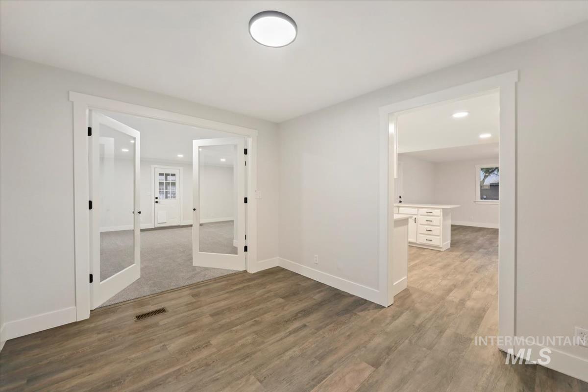 Spare room featuring light wood-style floors, recessed lighting, and french doors