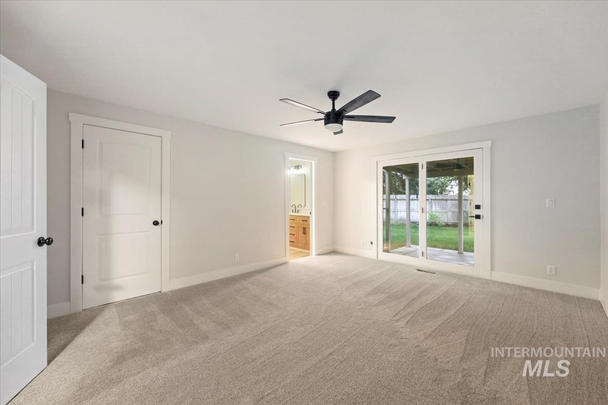 Unfurnished bedroom featuring carpet flooring, ensuite bathroom, access to exterior, and ceiling fan