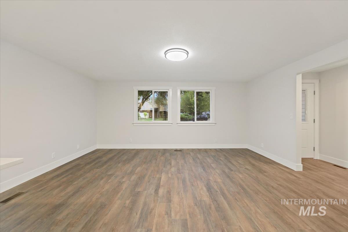 Empty room featuring wood finished floors and baseboards