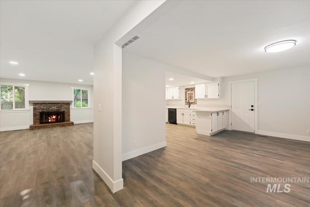 Unfurnished living room with recessed lighting, a fireplace, and dark wood-style floors