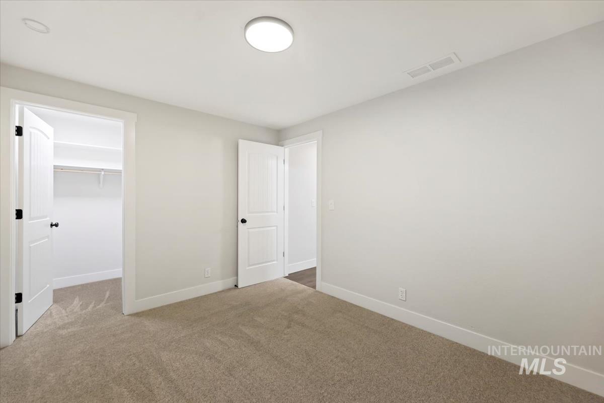Unfurnished bedroom with carpet floors and a walk in closet