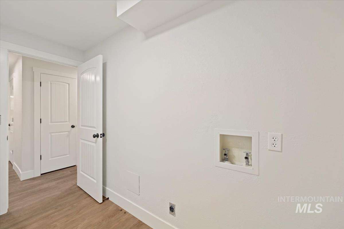 Laundry area featuring washer hookup, light wood-type flooring, and hookup for an electric dryer