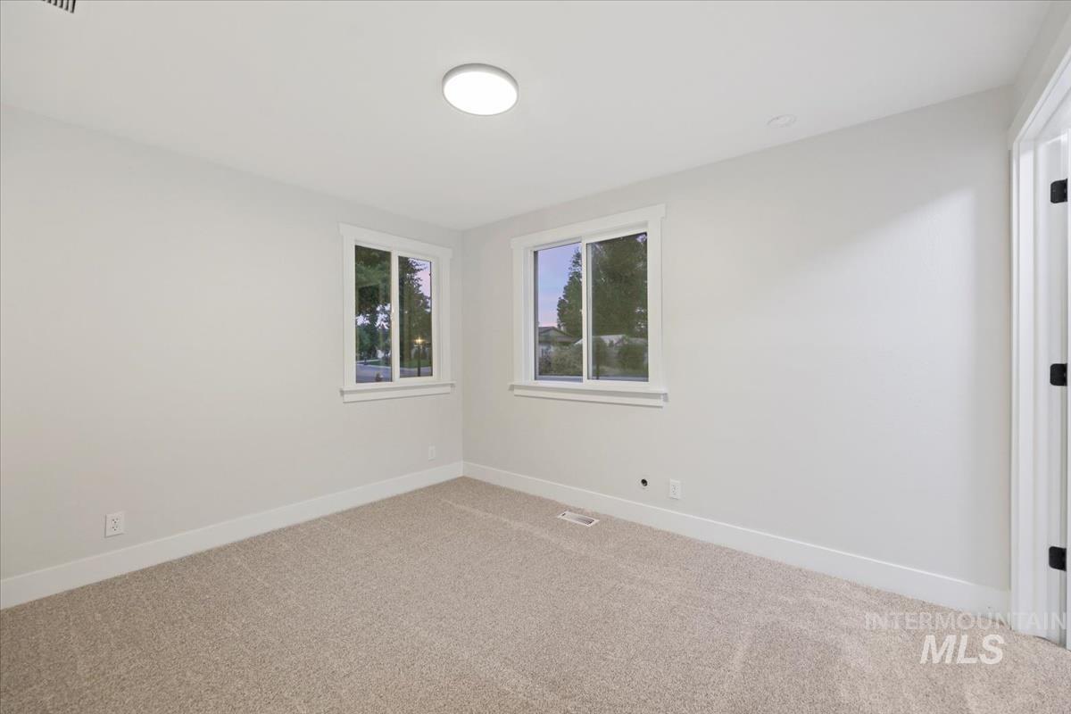 Unfurnished room featuring baseboards and light colored carpet