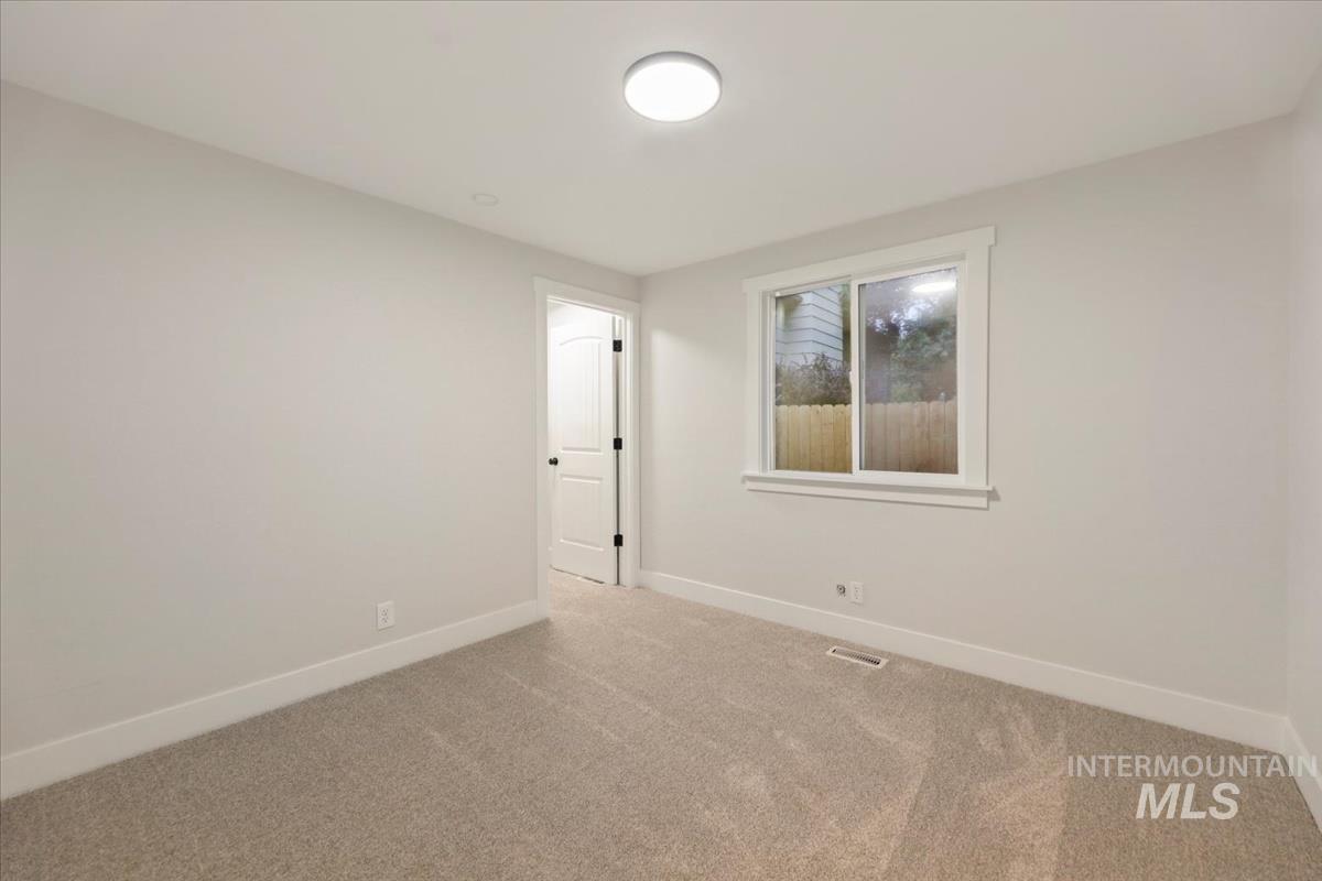 Unfurnished room with baseboards and light carpet