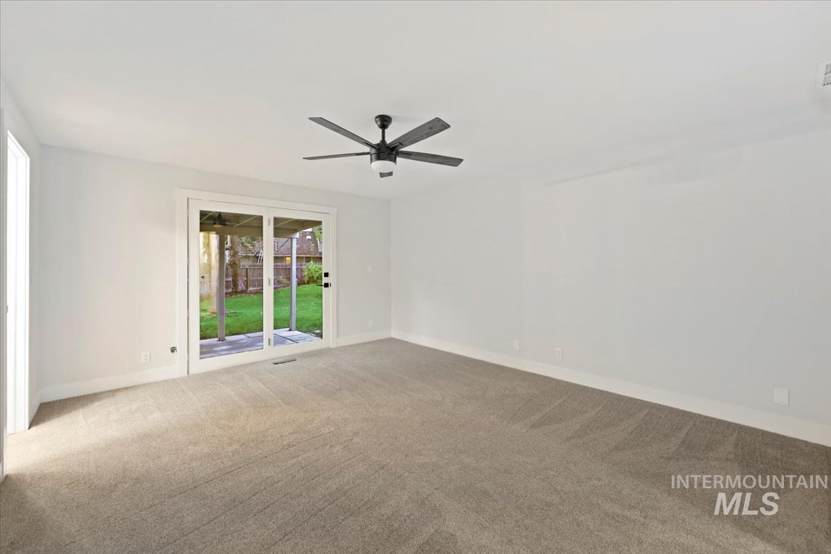 Spare room with carpet floors and a ceiling fan