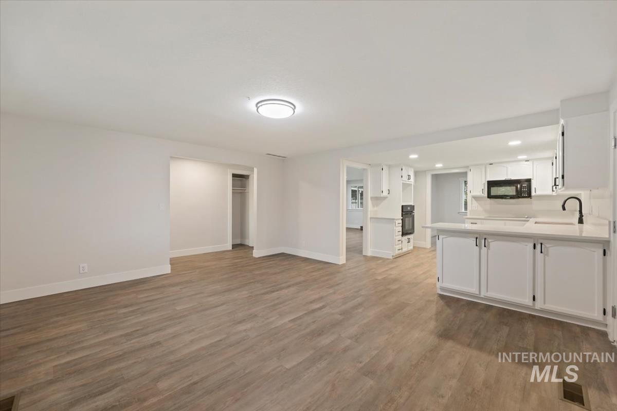 Unfurnished living room featuring dark wood finished floors and recessed lighting