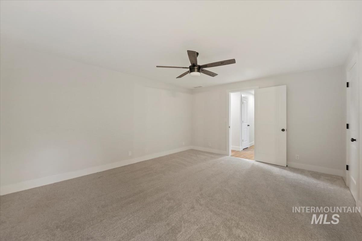 Empty room with light carpet and ceiling fan