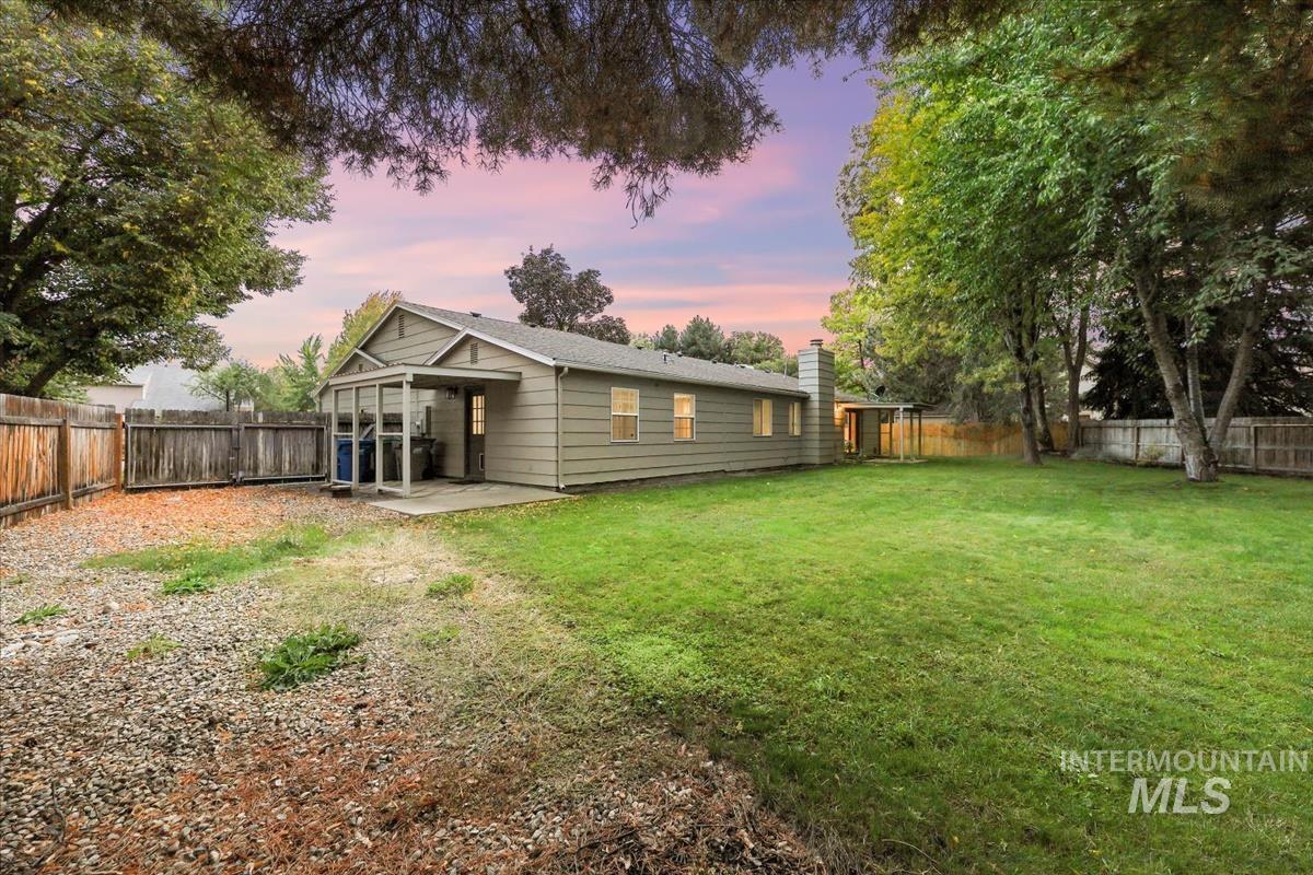 Rear view of house featuring a patio area, a fenced backyard, and a chimney