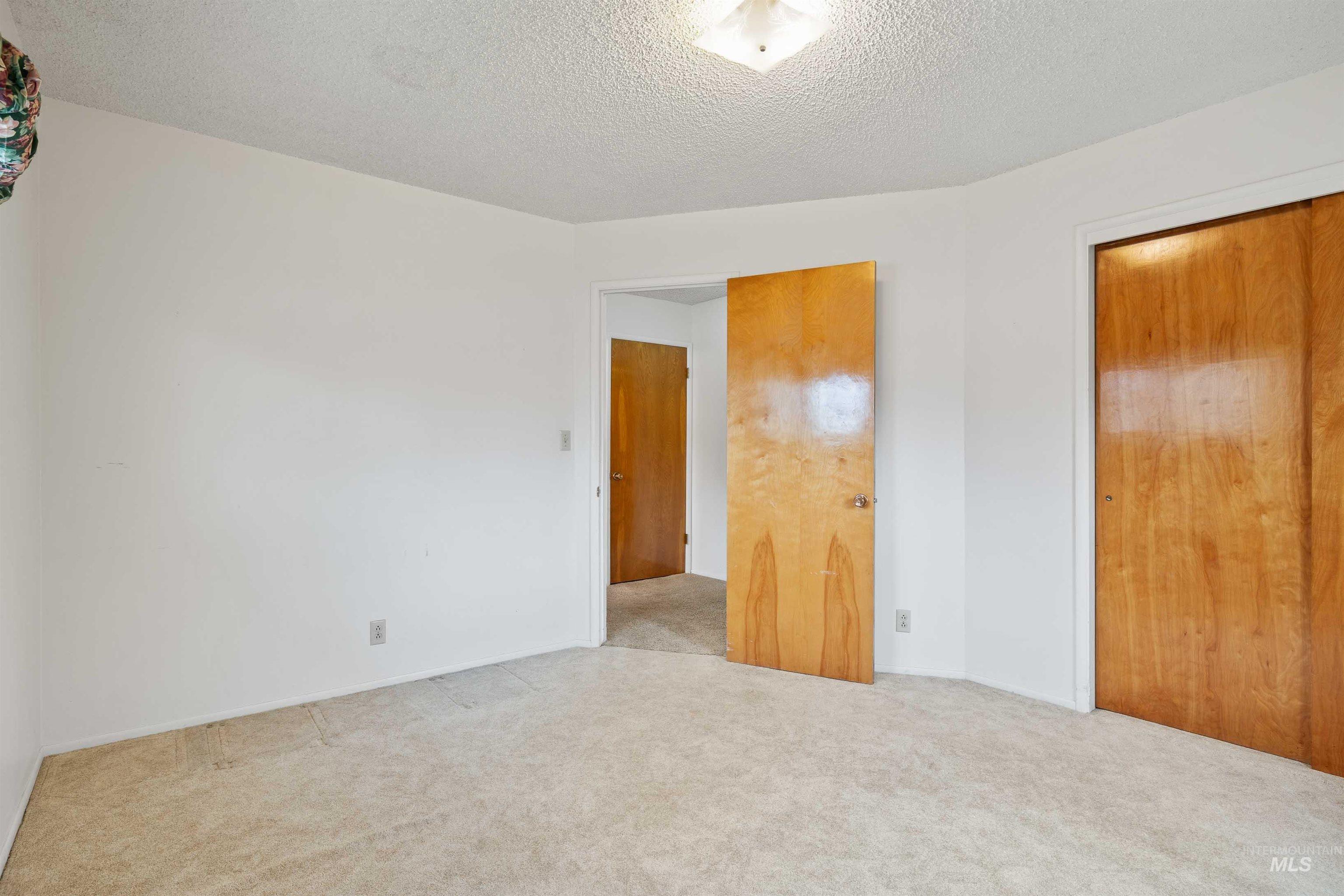Unfurnished bedroom with a closet, a textured ceiling, and carpet floors