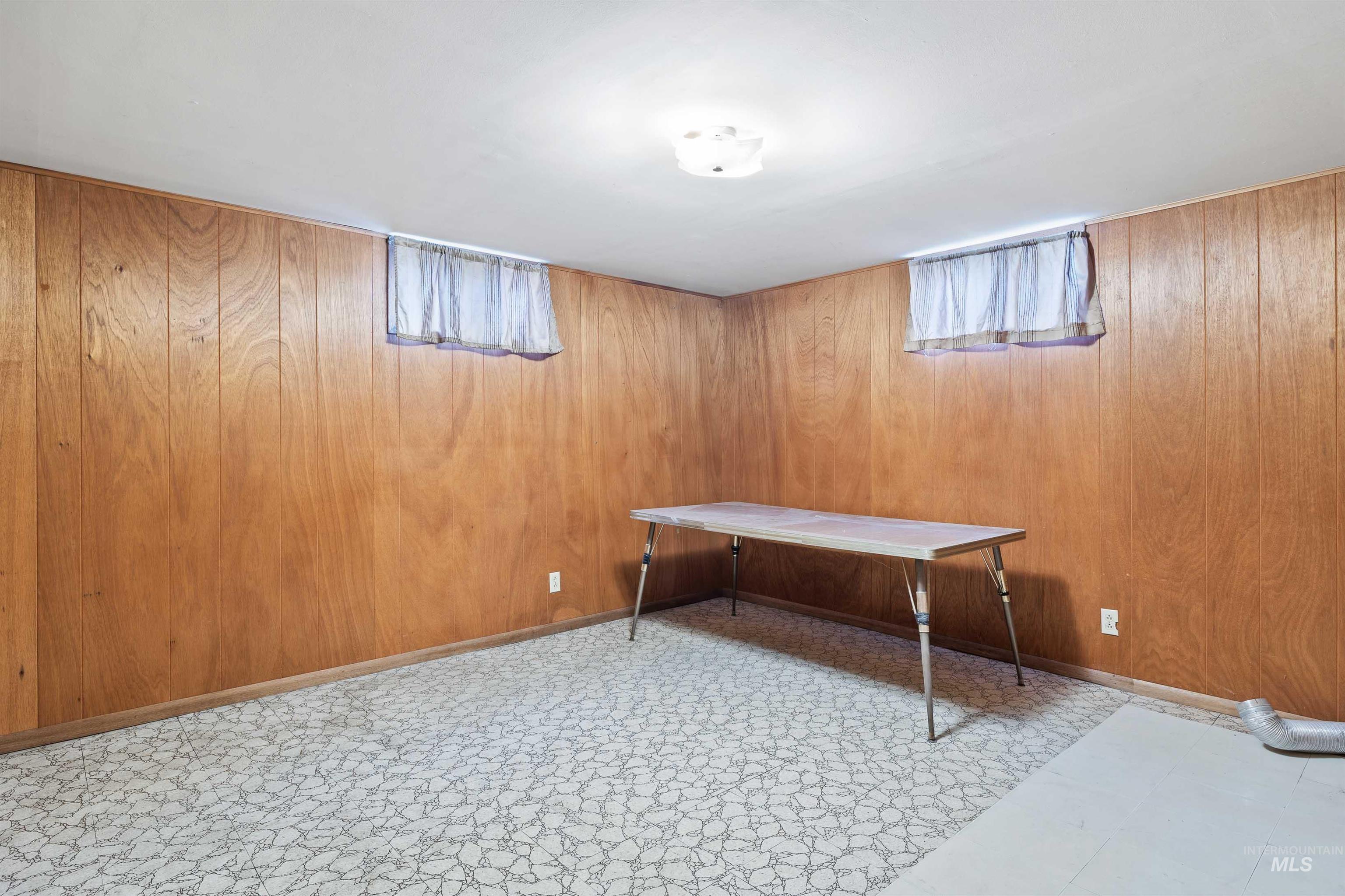 Recreation room with wood walls, tile patterned floors, and healthy amount of natural light