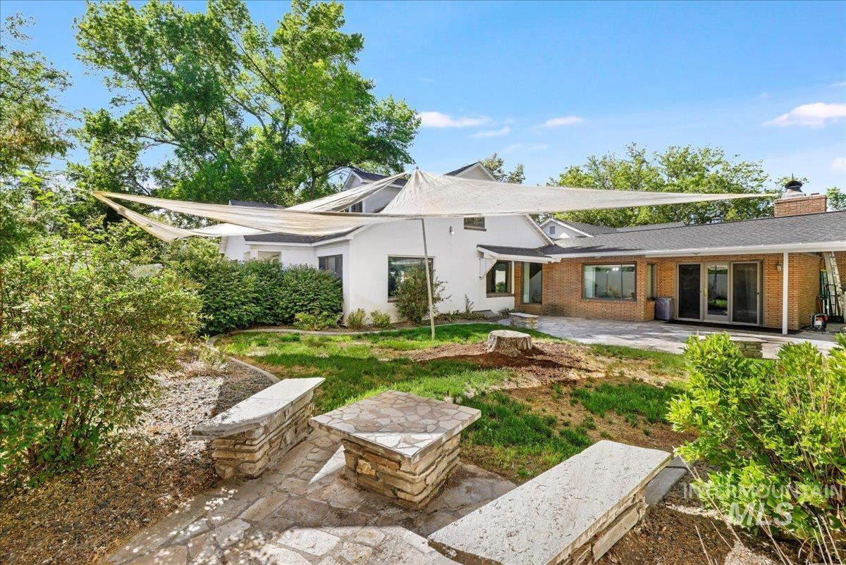 Back of property featuring a patio area, brick siding, and a chimney