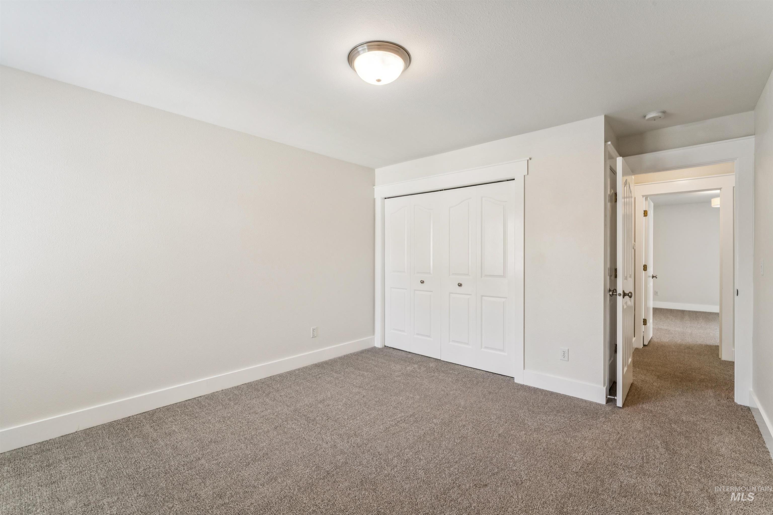 Unfurnished bedroom with dark colored carpet and a closet