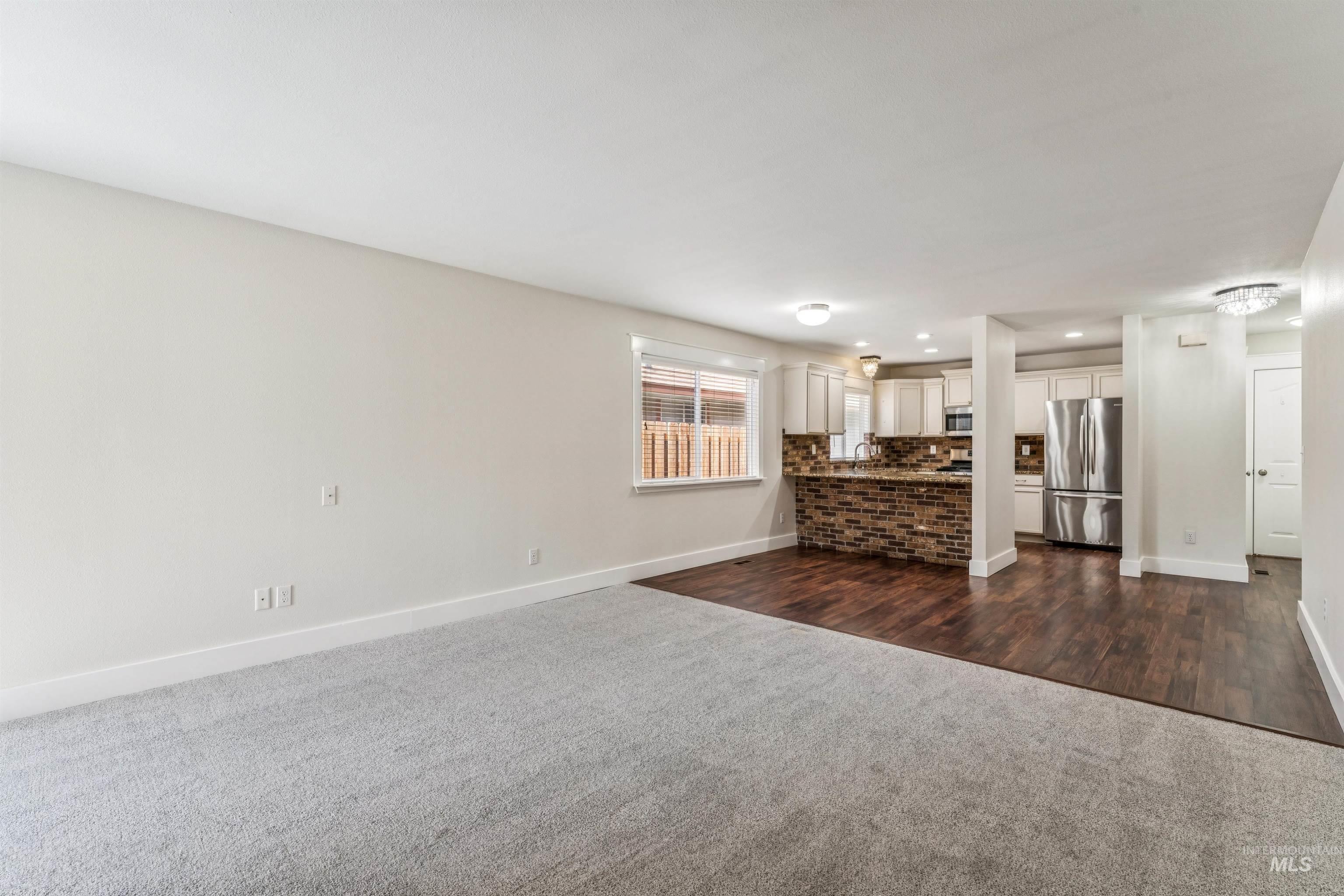 Living room featuring dark colored carpet and recessed lighting