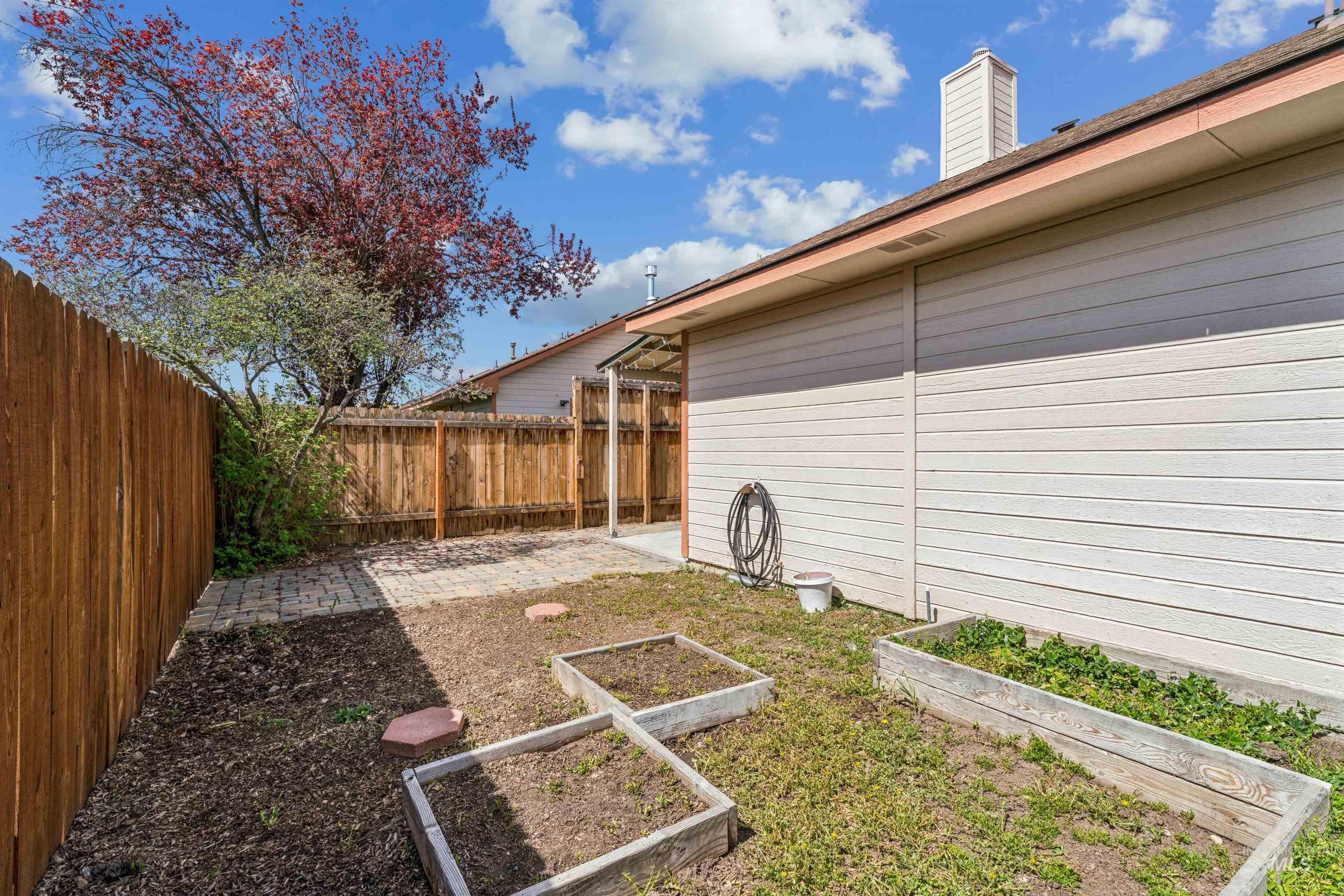 Fenced backyard featuring a garden