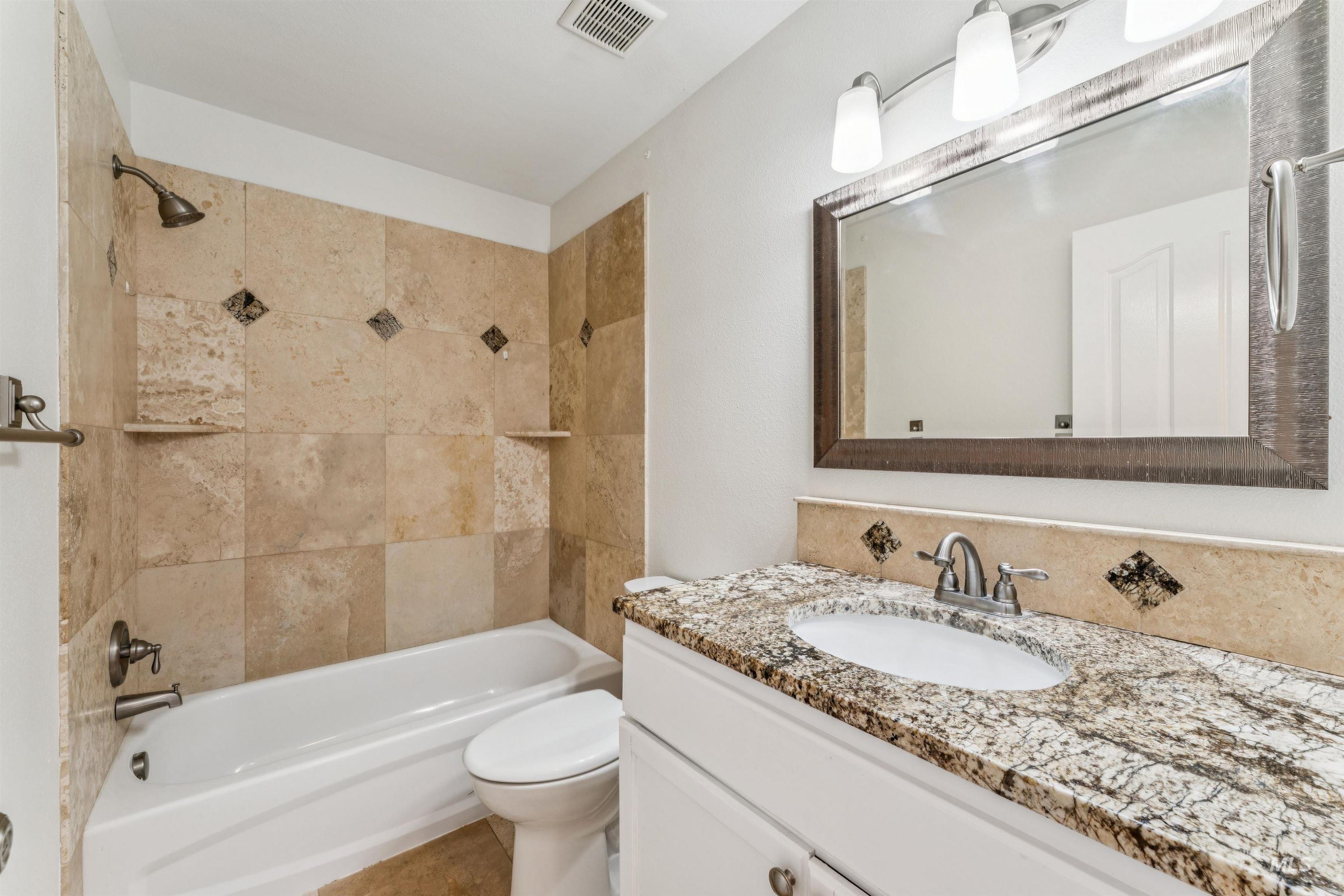 Bathroom with vanity and bathtub / shower combination